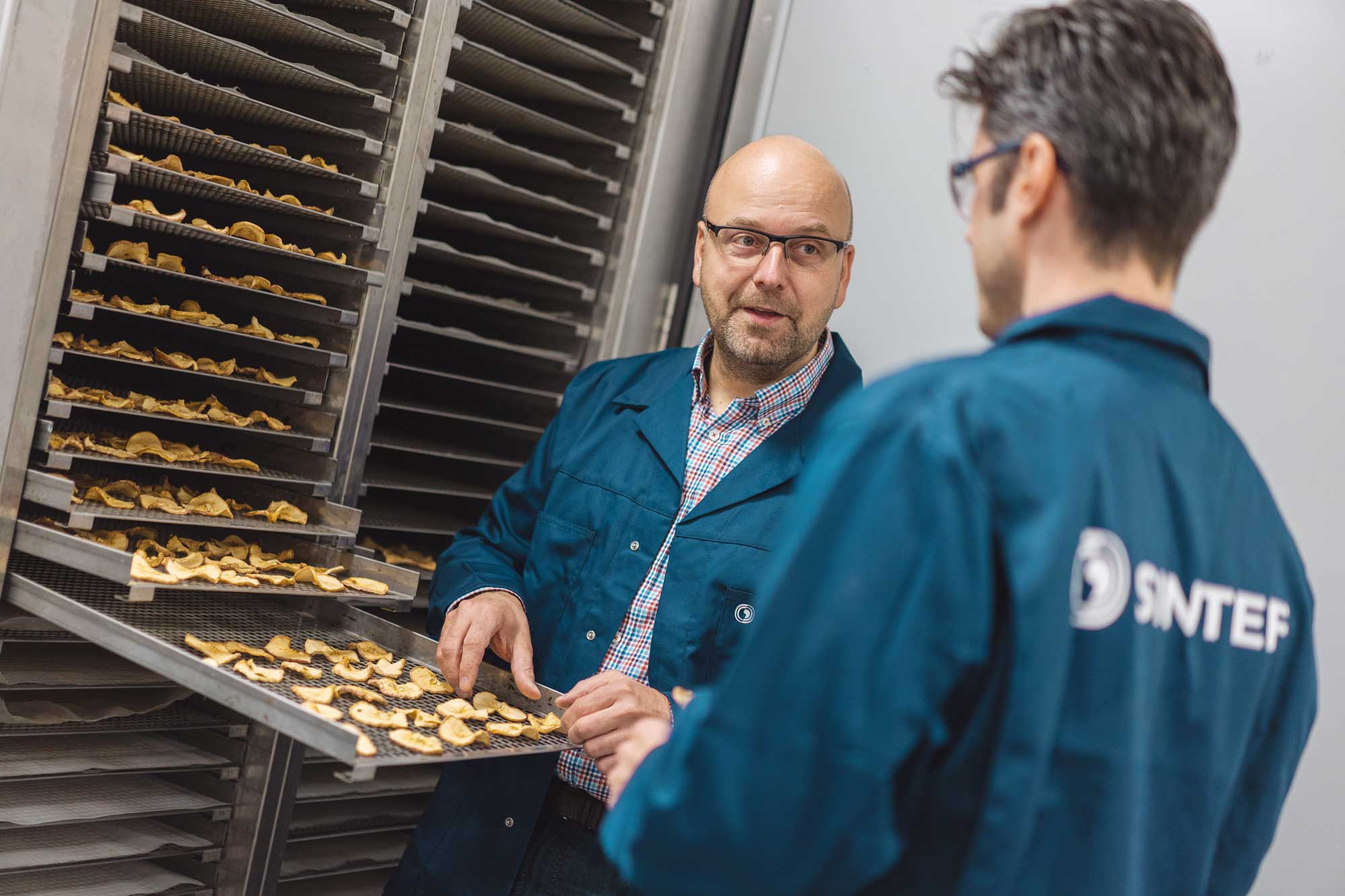 To forskere står ved en tørkemaskin i et laboratorie.