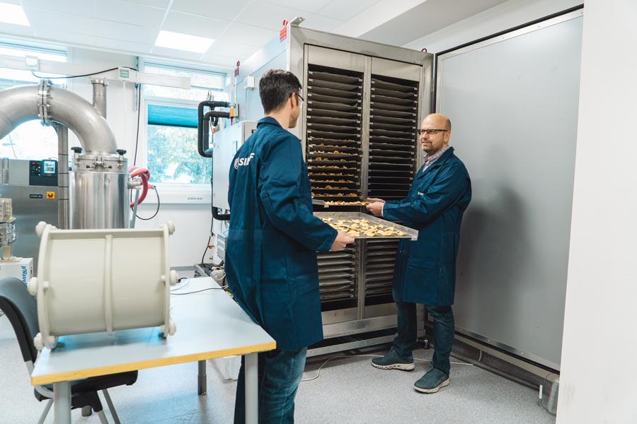 To forskere står ved en tørkemaskin i et laboratorie..