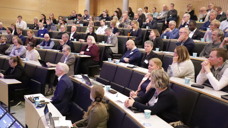 A group of people attending a conference in an auditorium.