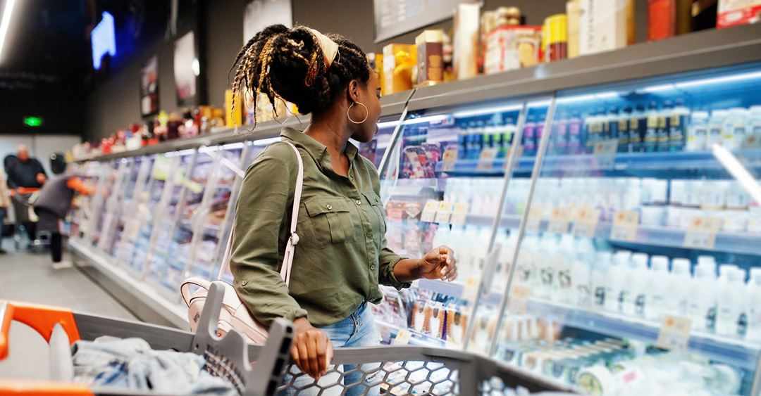 Woman in front of fridge at supermarket