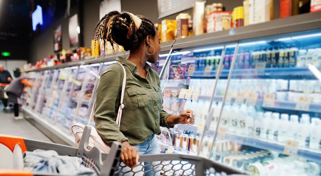 Woman in front of fridge at supermarket