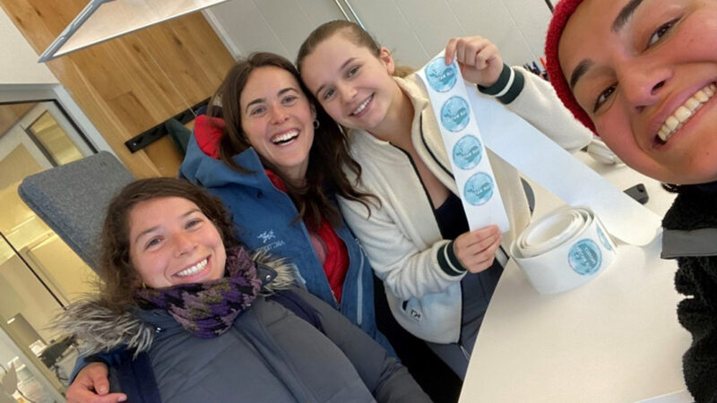 Four happy women, one holding stickers