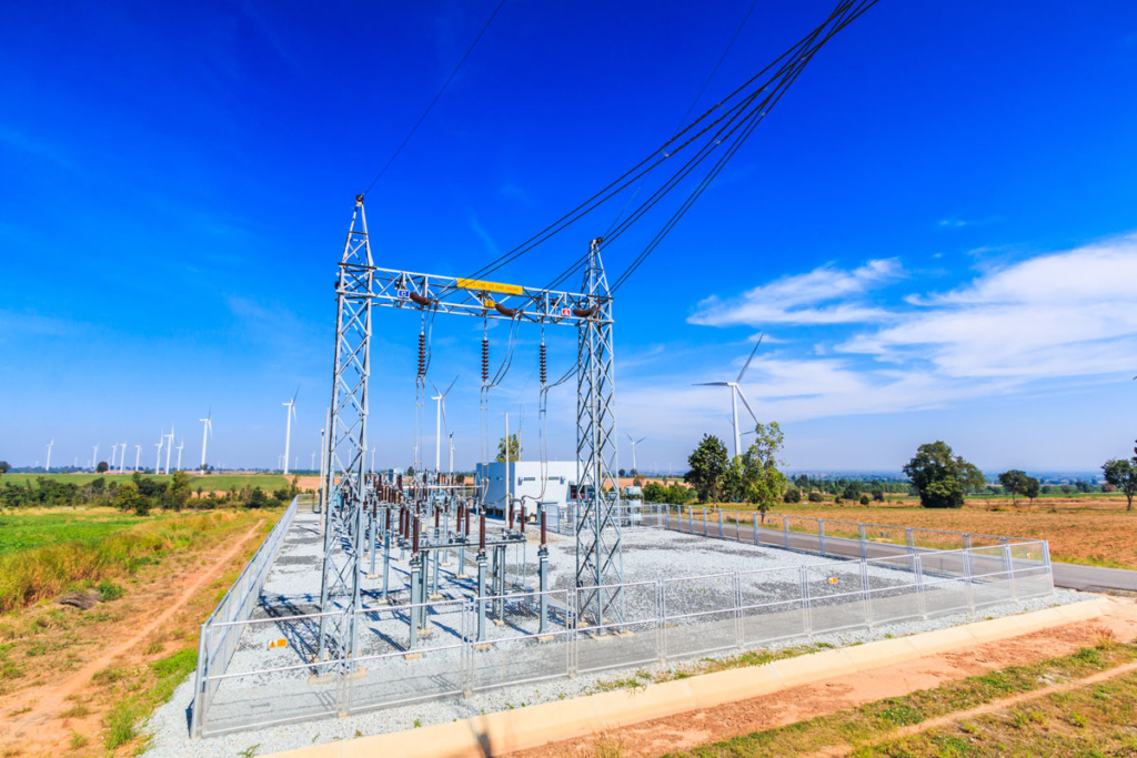 nettstasjon i strømnettet og vindturbiner i bakgrunnen